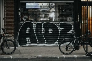 a bicycle parked in front of a building with graffiti on it