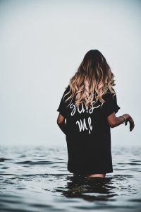 woman in black and white t-shirt standing on water during daytime