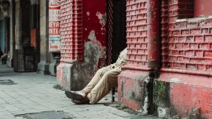 a person laying on the ground in front of a red building